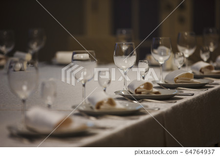 Row of place settings on table for a wedding reception 64764937