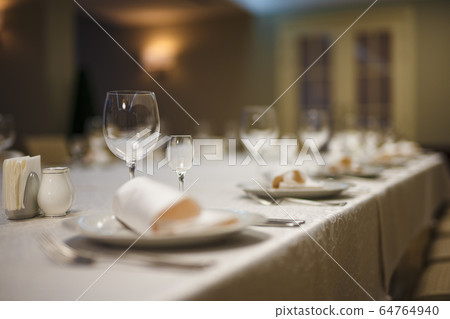 Row of place settings on table for a wedding reception Row of place settings on table for a wedding reception 64764940