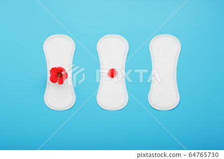 Three Sanitary pads on a blue background. The 64765730