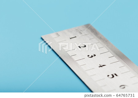 Metal ruler on a blue background close-up with a Metal ruler on a blue background close-up with a 64765731