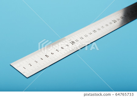 A metal ruler with a scale on a blue background is 64765733