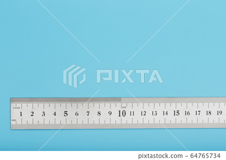 A metal ruler with a scale on a blue background is 64765734
