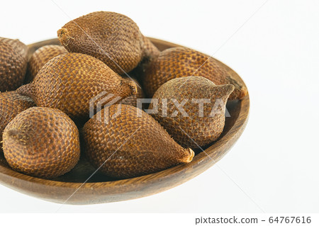 bamboo plate full of dark brown snake fruit stands 64767616