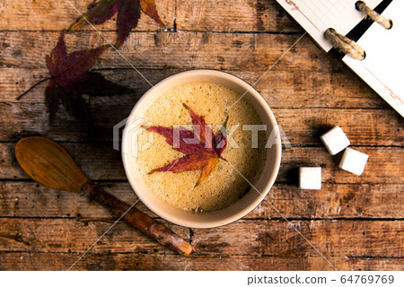 Coffee with autumn leaf on a table Coffee with autumn leaf on a table 64769769