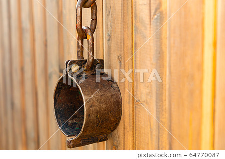 old iron shackles hanging on chains on wooden old iron shackles hanging on chains on wooden 64770087