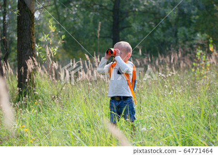 Young explorer watching with binoculars of birds Young explorer watching with binoculars of birds 64771464