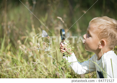 Young researcher explores nature with a magnifying 64771527