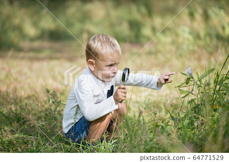 Young researcher explores nature with a magnifying 64771529