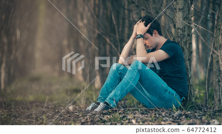 Unhappy man in the forest suffers from depression and frustration of life. copy space Unhappy man in the forest suffers from depression and frustration of life. copy space 64772412