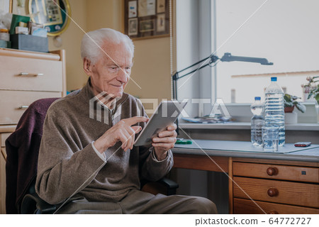 Positive Senior using Digital Tablet 64772727
