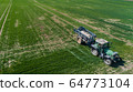 Agriculture Tractor Working in Field Spraying Herbicides 64773104