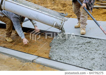 Pouring concrete to create in the walking sidewalk 64776275