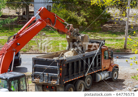 Truck with excavator loading for removal of debris Truck with excavator loading for removal of debris 64776575