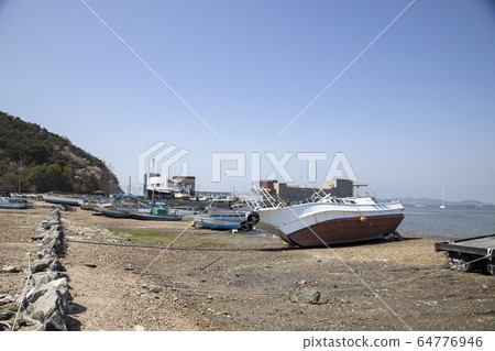A ship lying askew on the sandy beach 64776946