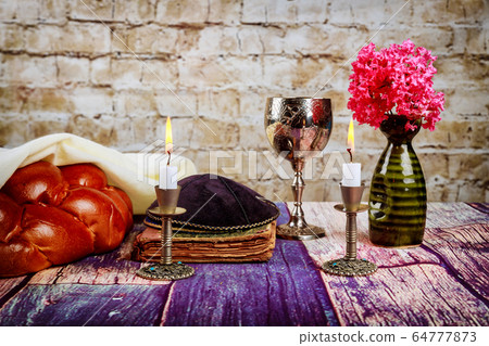 Shabbat candles in candlesticks of loaves challah 64777873