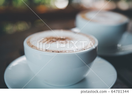 Coffee in white cup on table at coffee shop Coffee in white cup on table at coffee shop 64781344