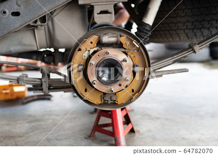 Drum brake and asbestos brake pads at car garage 64782070