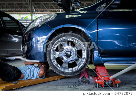 Checking a car engine for repair at car garage 64782072