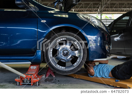 Checking a car engine for repair at car garage 64782073