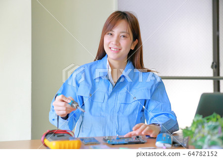 Female engineer working with soldering iron 64782152