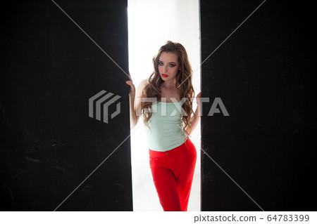 Beautiful fashionable woman with long hair sitting on the floor Beautiful fashionable woman with long hair sitting on the floor 64783399