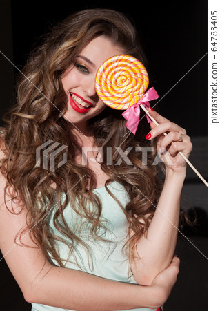 woman with long hair eats candy sweet lollipop 64783405