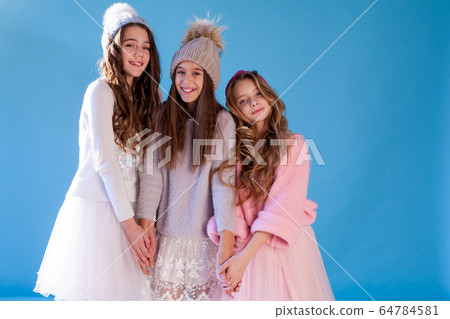 Three beautiful fashionable girls in winter snow caps Three beautiful fashionable girls in winter snow caps 64784581