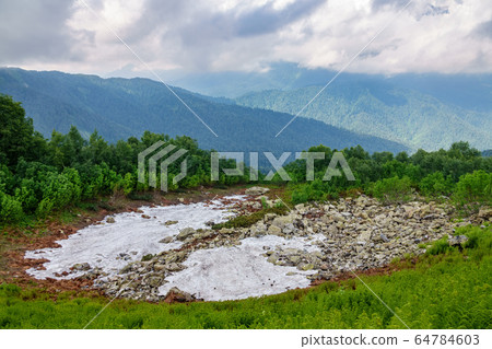 A layer of melting snow in high mountains. A layer of melting snow in high mountains. 64784603