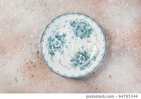 Antique porcelain plate on concrete 64785144