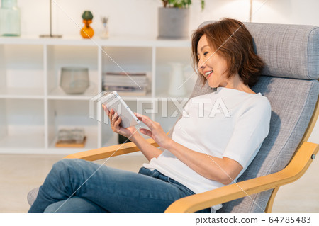 看片劑的資深婦女在屋子裡 看片劑的資深婦女在屋子裡 64785483