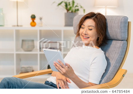 看片劑的資深婦女在屋子裡 看片劑的資深婦女在屋子裡 64785484