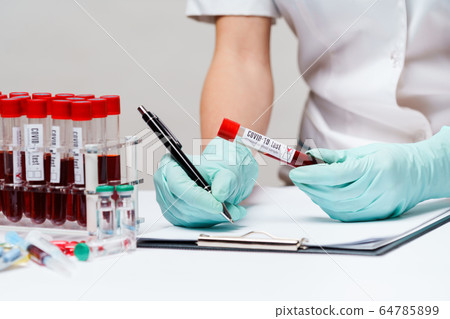 woman docxtor working with blood test tubes woman docxtor working with blood test tubes 64785899