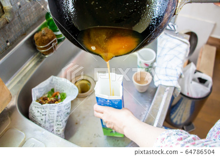 家庭主婦把廢油扔進牛奶紙箱 家庭主婦把廢油扔進牛奶紙箱 64786504