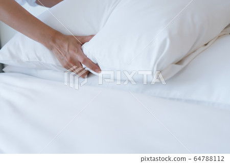Female Hand set up white bed sheet in bedroom Female Hand set up white bed sheet in bedroom 64788112
