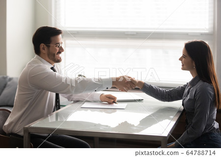 Smiling woman candidate shaking hands with businessman at job interview. Smiling woman candidate shaking hands with businessman at job interview. 64788714