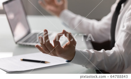 Close up businessman hands in meditation lotus posture. 64788843