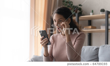 Happy female client shocked by sale price in internet store. Happy female client shocked by sale price in internet store. 64789193