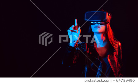 girl in 3D virtual reality glasses touches the projection screen with her finger girl in 3D virtual reality glasses touches the projection screen with her finger 64789490