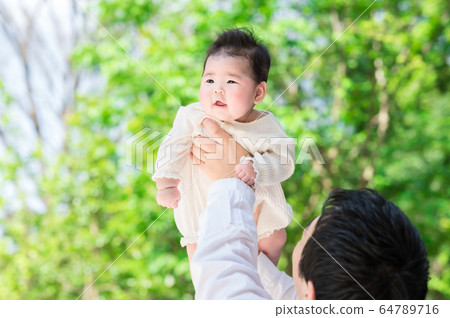 A baby held in a dad A baby held in a dad 64789716