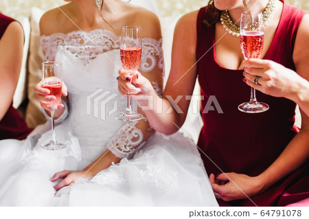 bride and her friends at the wedding celebrate with glasses of champagne in the hands bride and her friends at the wedding celebrate with glasses of champagne in the hands 64791078