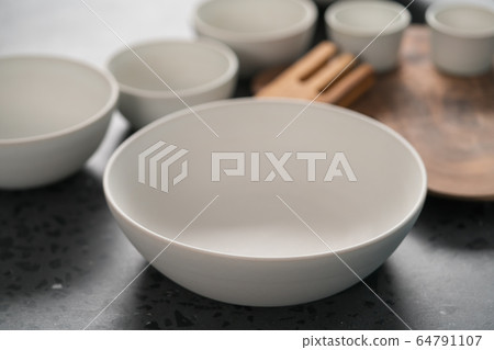 Empty matt white ceramic handmade tableware set on concrete countertop 64791107