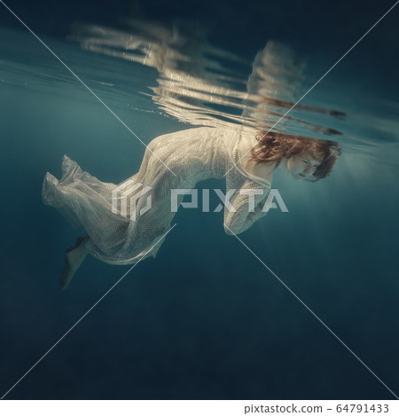 Girl in a sequined dress swims underwater Girl in a sequined dress swims underwater 64791433