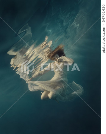 Girl in a sequined dress swims underwater Girl in a sequined dress swims underwater 64791436