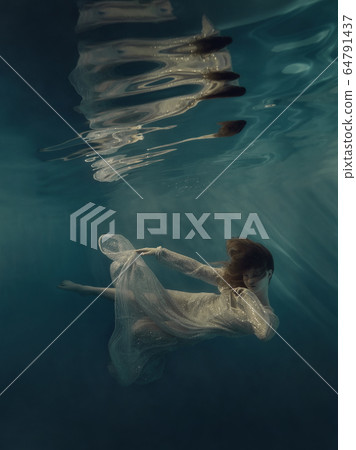 Girl in a sequined dress swims underwater Girl in a sequined dress swims underwater 64791437