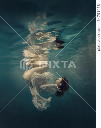 Girl in a sequined dress swims underwater Girl in a sequined dress swims underwater 64791438