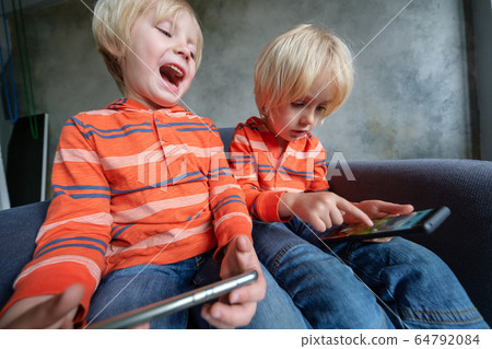 Brothers are watching or playing or learning something in a smartphone Brothers are watching or playing or learning something in a smartphone 64792084