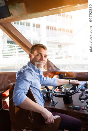A man drives a sea pleasure boat 64792880