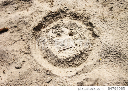Sad or unhappy face drawn on sand at beach. Sad or unhappy face drawn on sand at beach. 64794065
