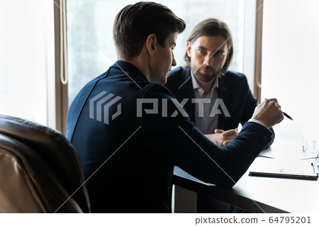Two business partners discussing project strategy, working together Two business partners discussing project strategy, working together 64795201