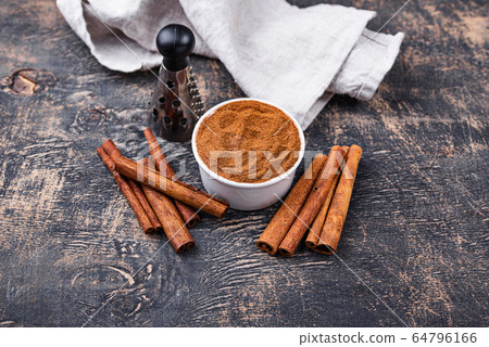Cinnamon sticks and powder on black 64796166